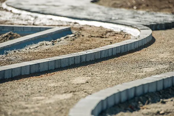 Concrete edging and kerb laid on a compacted sand base during site preparation